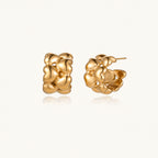 Close-up of gold-plated twisted rope huggie hoop earrings with brushed finish on white background.