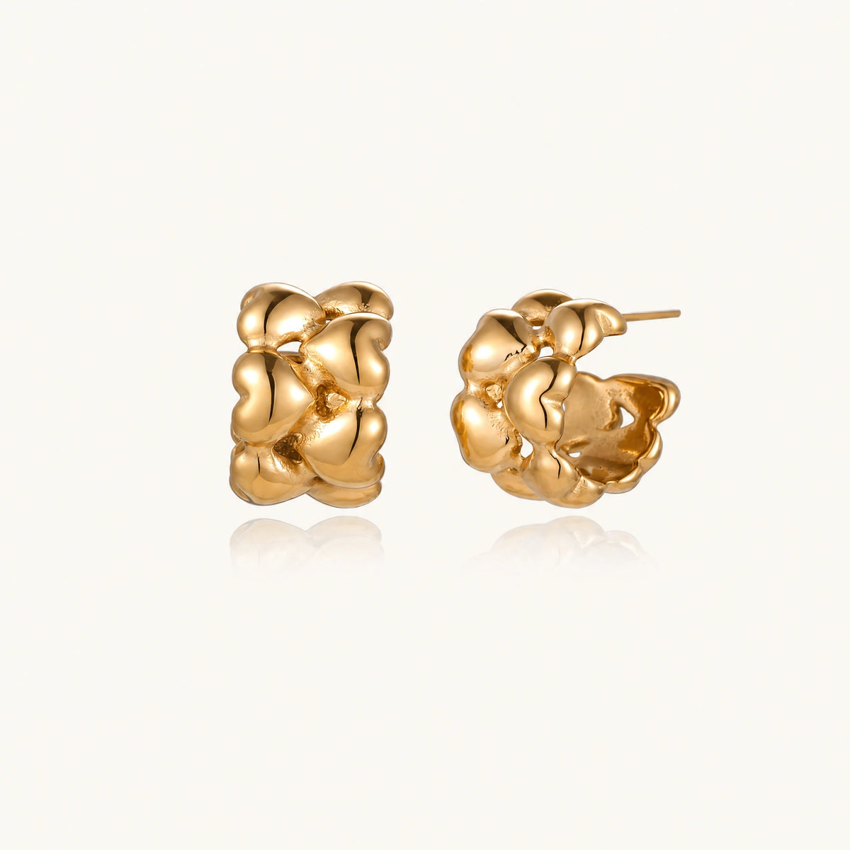 Close-up of gold-plated twisted rope huggie hoop earrings with brushed finish on white background.