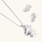 Modern sculptural jewelry set with flowing ribbon-like earrings and matching pendant in eco-zinc alloy finish