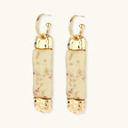 Cylindrical bar earrings featuring speckled natural resin center with polished metal caps and lever-back closures