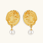 Ornate gold-plated dragon medallion earrings with white shell pearl drops on beige background, featuring detailed Chinese motifs.