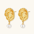 Ornate gold-plated dragon medallion earrings with white shell pearl drops on beige background, featuring detailed Chinese motifs.