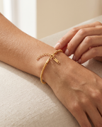 Wrist wearing the Golden Hour Chain Bracelet beside a gift box