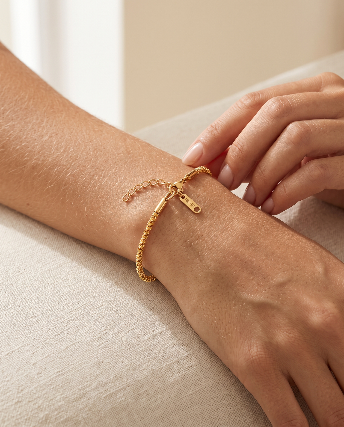 Wrist wearing the Golden Hour Chain Bracelet beside a gift box