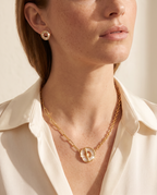 Woman wearing the Radiant Circle Jewelry Set, round baguette-stone pendant and studs