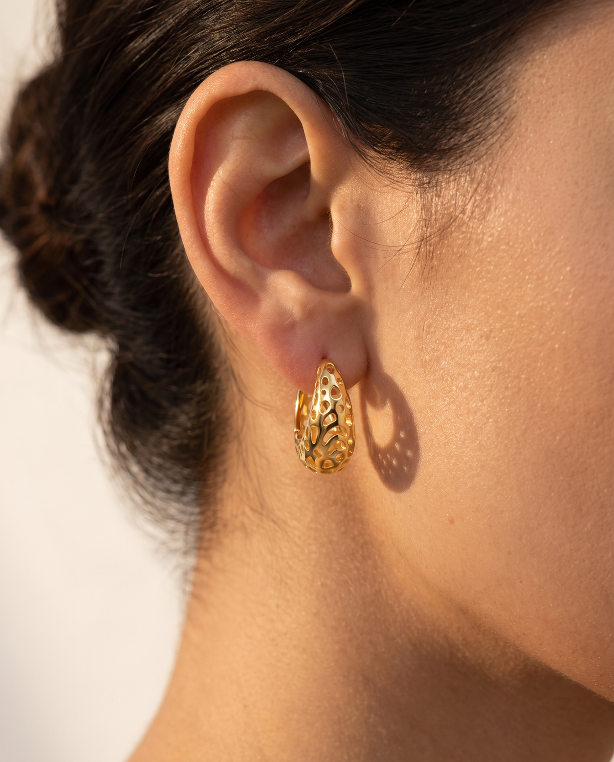 Honeycomb Dream Hoops worn on the ear, gold openwork hoop