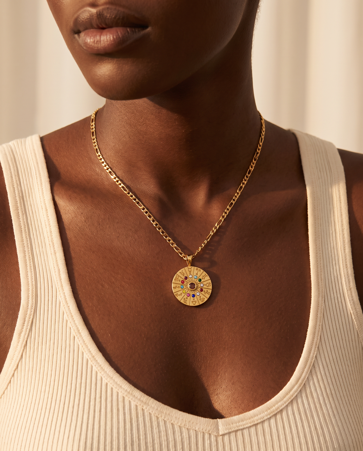 Woman wearing the Zodiac Wheel Necklace, gold medallion on figaro chain