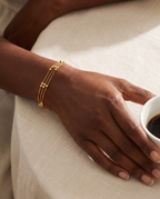 Wrist wearing the Golden Orbit Bracelet, three beaded gold chains